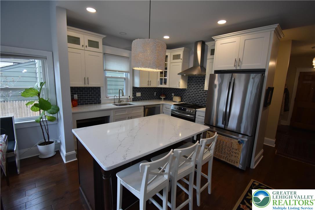 715 Coleman Street Easton, PA 18042 - Photo 12 of 38 a kitchen with stainless steel appliances granite countertop a refrigerator a stove a sink a dining table and chairs