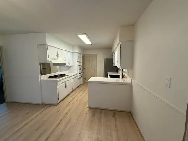 a kitchen with white cabinets and white appliances