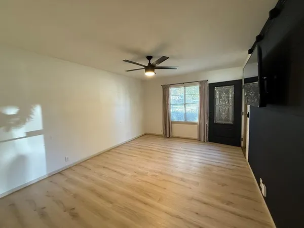 wooden floor in an empty room with a window