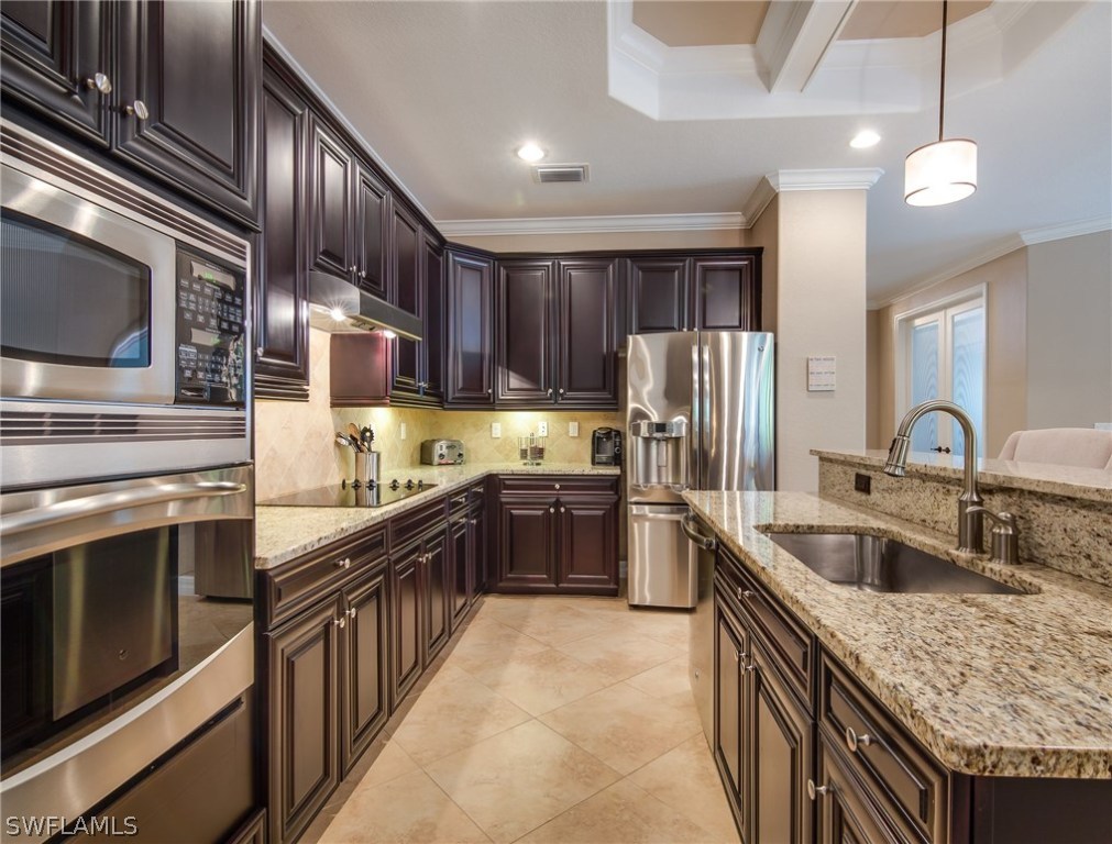9495 Piacere Way Naples, FL 34113 - Photo 11 of 25 a kitchen with stainless steel appliances granite countertop a sink stove and refrigerator