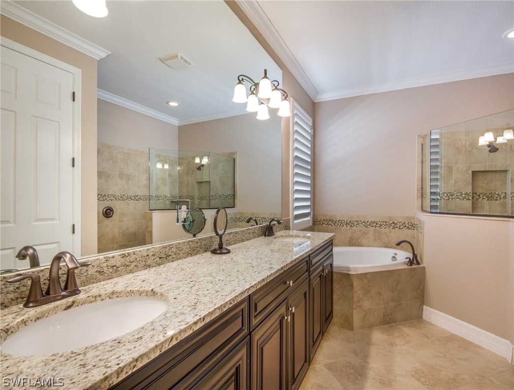 9495 Piacere Way Naples, FL 34113 - Photo 14 of 25 a bathroom with a granite countertop sink a large mirror and a bathtub