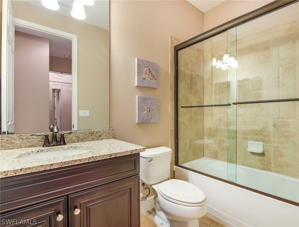 9495 Piacere Way Naples, FL 34113 - Photo 16 of 25 a bathroom with a granite countertop sink toilet and shower