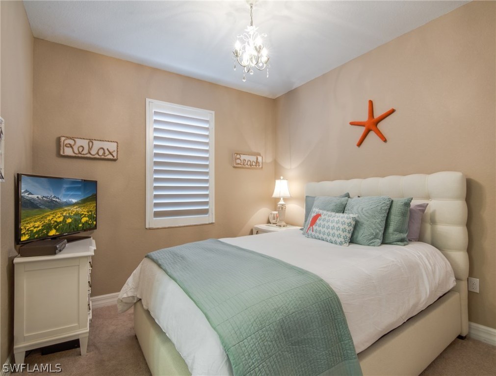 9495 Piacere Way Naples, FL 34113 - Photo 18 of 25 a bedroom with a bed and a chandelier