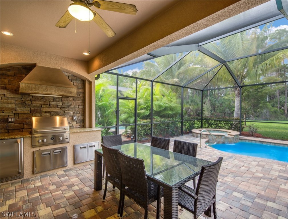 9495 Piacere Way Naples, FL 34113 - Photo 20 of 25 a dining room with stainless steel appliances granite countertop a dining table and chairs with the view of garden