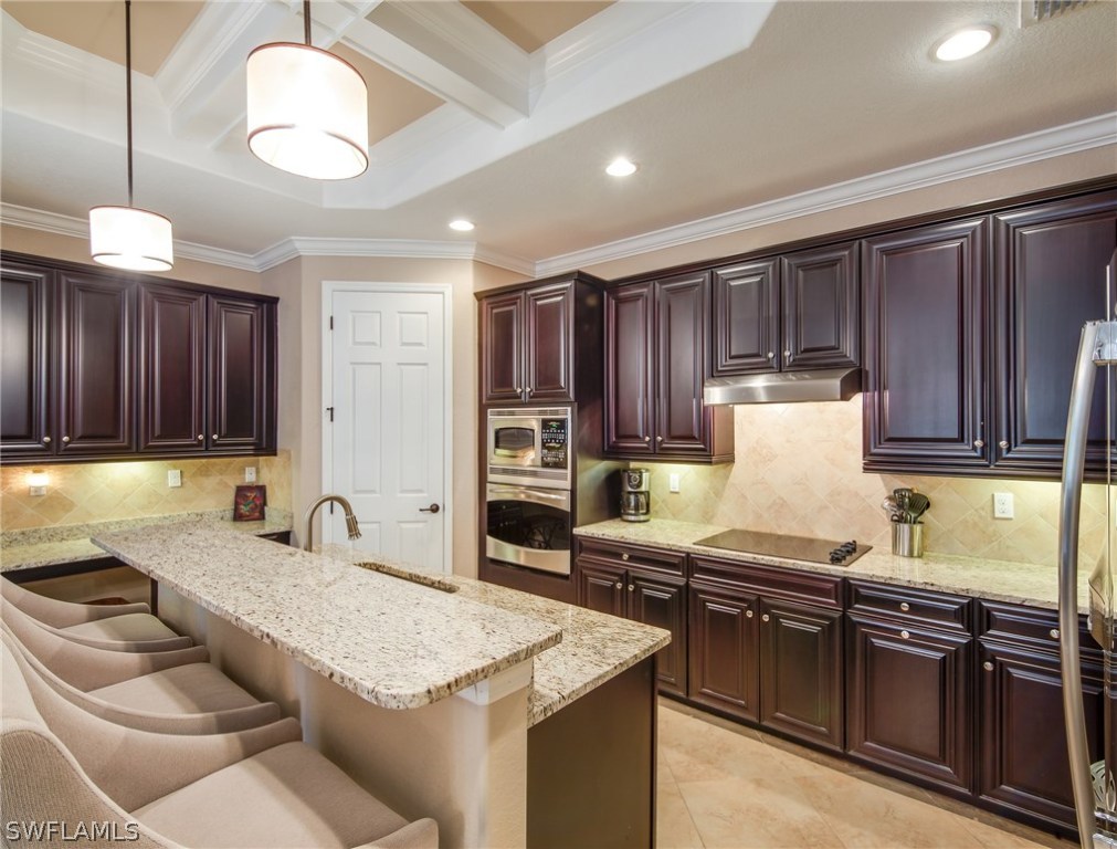 9495 Piacere Way Naples, FL 34113 - Photo 10 of 25 a kitchen with granite countertop lots of counter top space appliances and cabinets