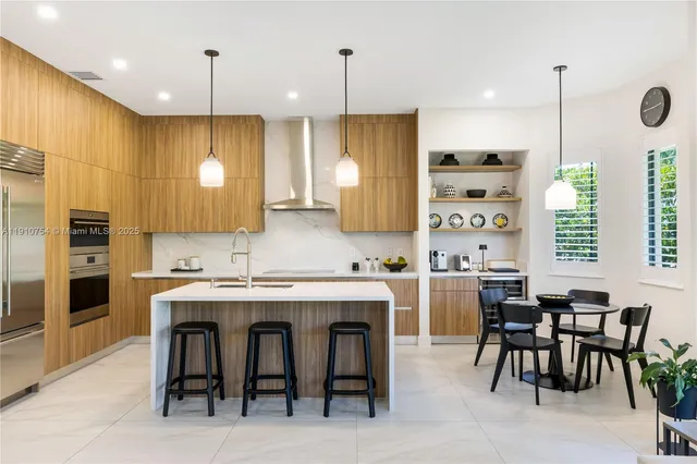 a large kitchen with a table chairs and refrigerator