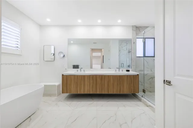 a bathroom with a double vanity sink a mirror and a bathtub