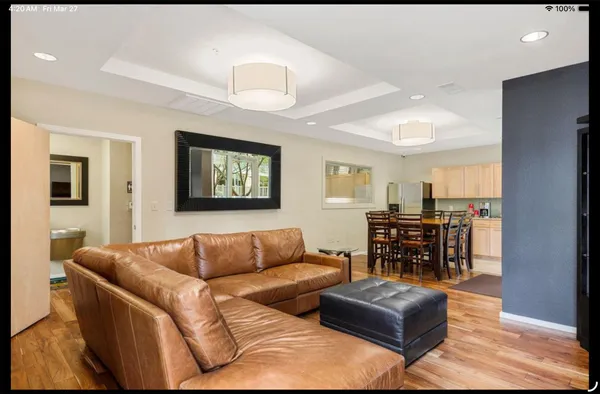 a living room with a couch and a view of kitchen