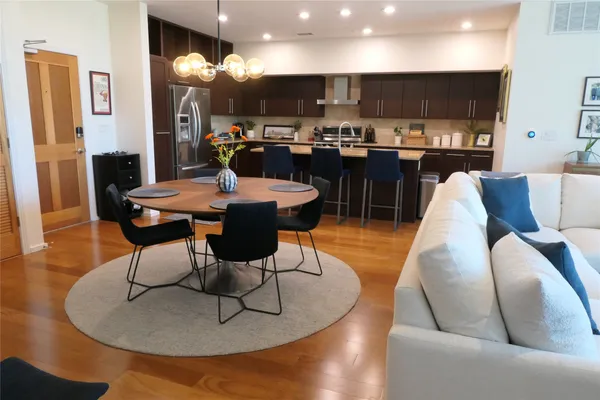 a living room with furniture kitchen view and a large window