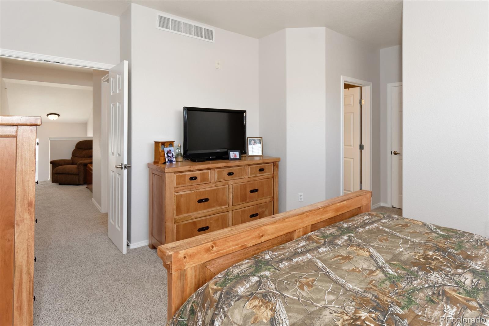 8440 Canyon Rim Trail, Unit 4 Parker, CO 80134 - Photo 13 of 28 a view of a bedroom with a flat tv screen and a bed