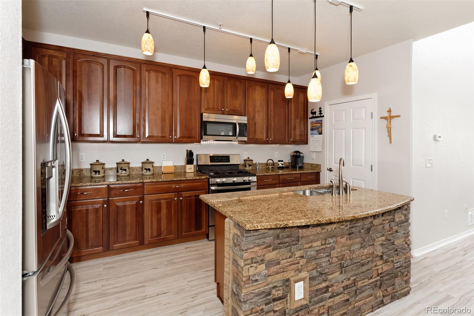 8440 Canyon Rim Trail, Unit 4 Parker, CO 80134 - Photo 4 of 28 a kitchen with stainless steel appliances granite countertop a stove a sink dishwasher and a refrigerator with wooden floor