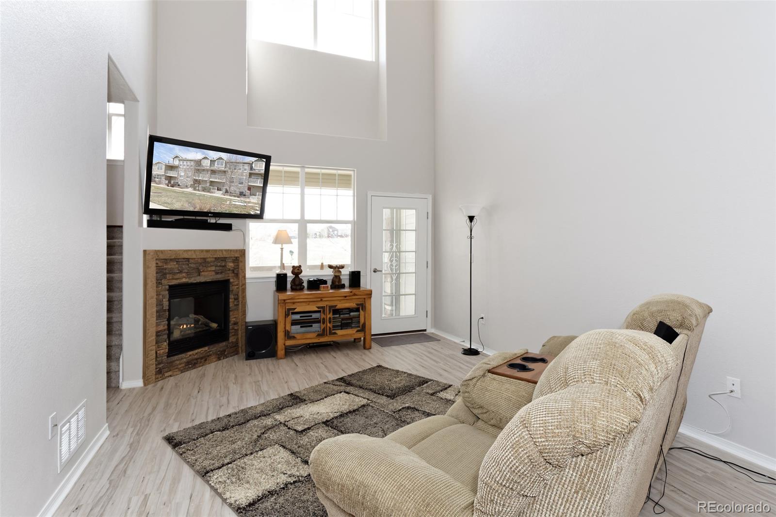 8440 Canyon Rim Trail, Unit 4 Parker, CO 80134 - Photo 10 of 28 a living room with furniture a flat screen tv and a fireplace