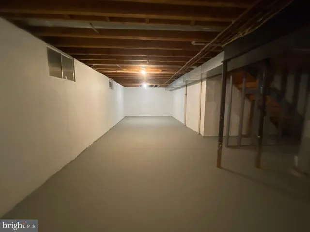 a view of an empty room with wooden floor and windows