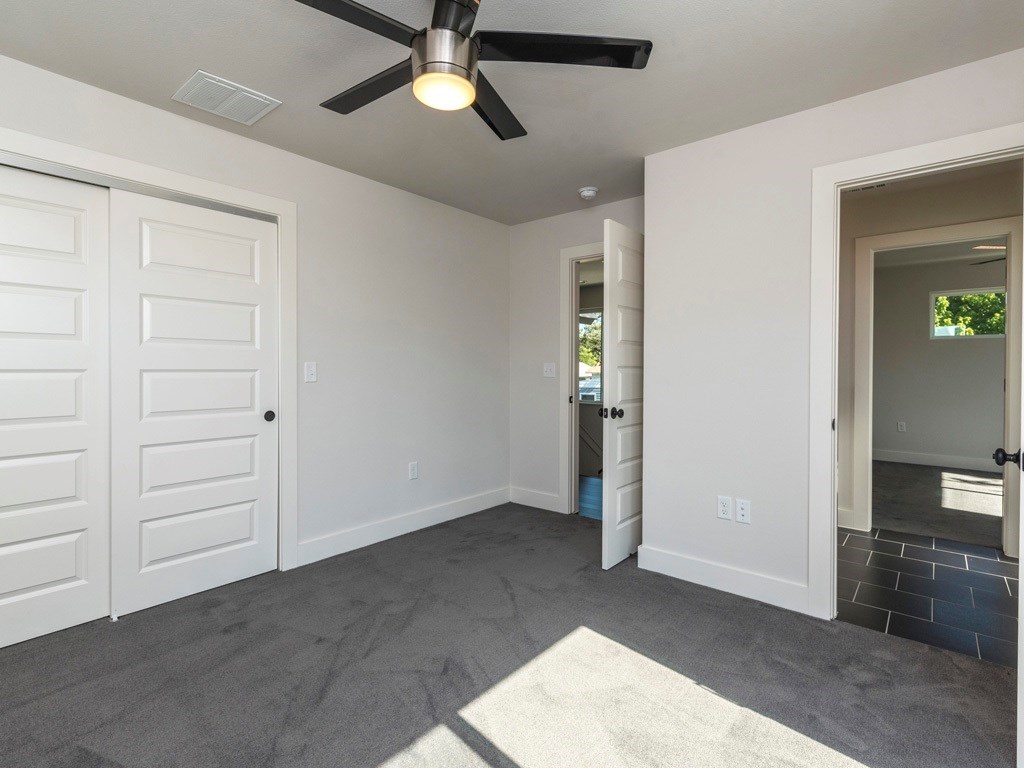 1182 Ridgeway Drive, Unit A Austin, TX 78702 - Photo 19 of 27 Unfurnished bedroom with dark colored carpet, a closet, and ceiling fan