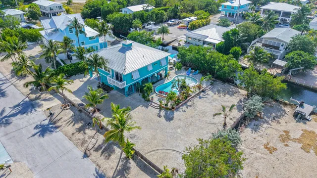 an aerial view of a house with a yard and lake view