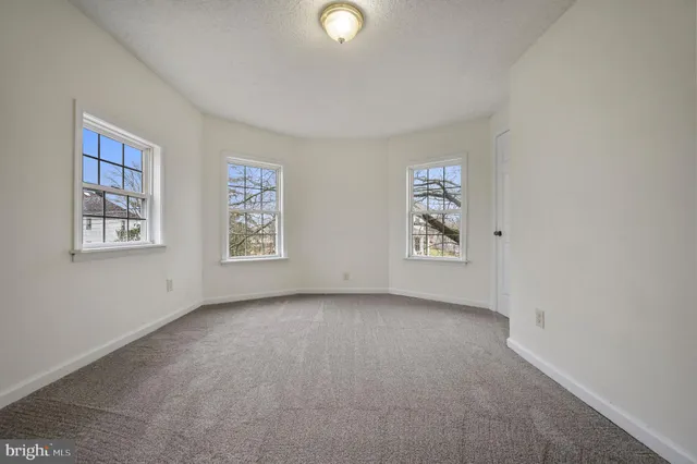 an empty room with windows and closet