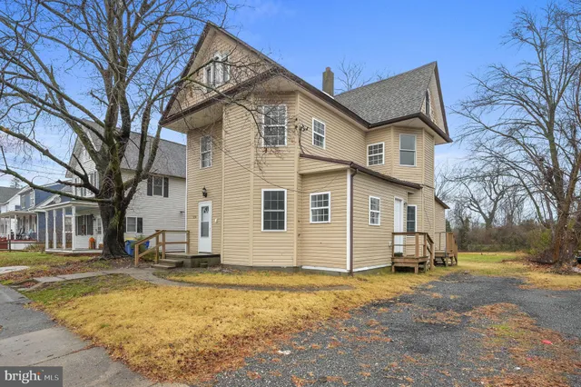 a view of a white house with a yard covered in snow