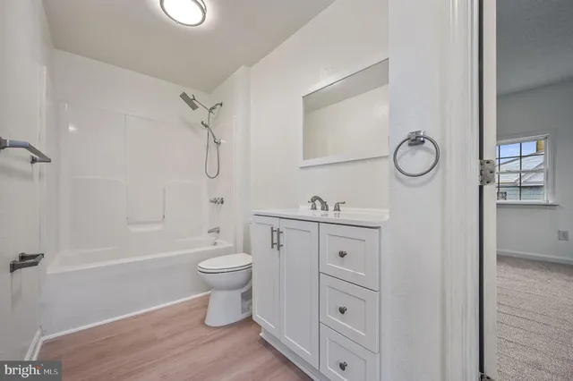 a bathroom with a granite countertop toilet a sink and a mirror