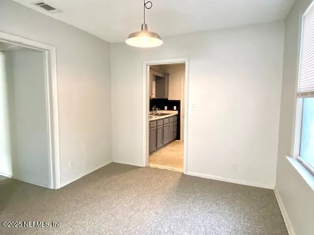 a view of an empty room with closet and a window