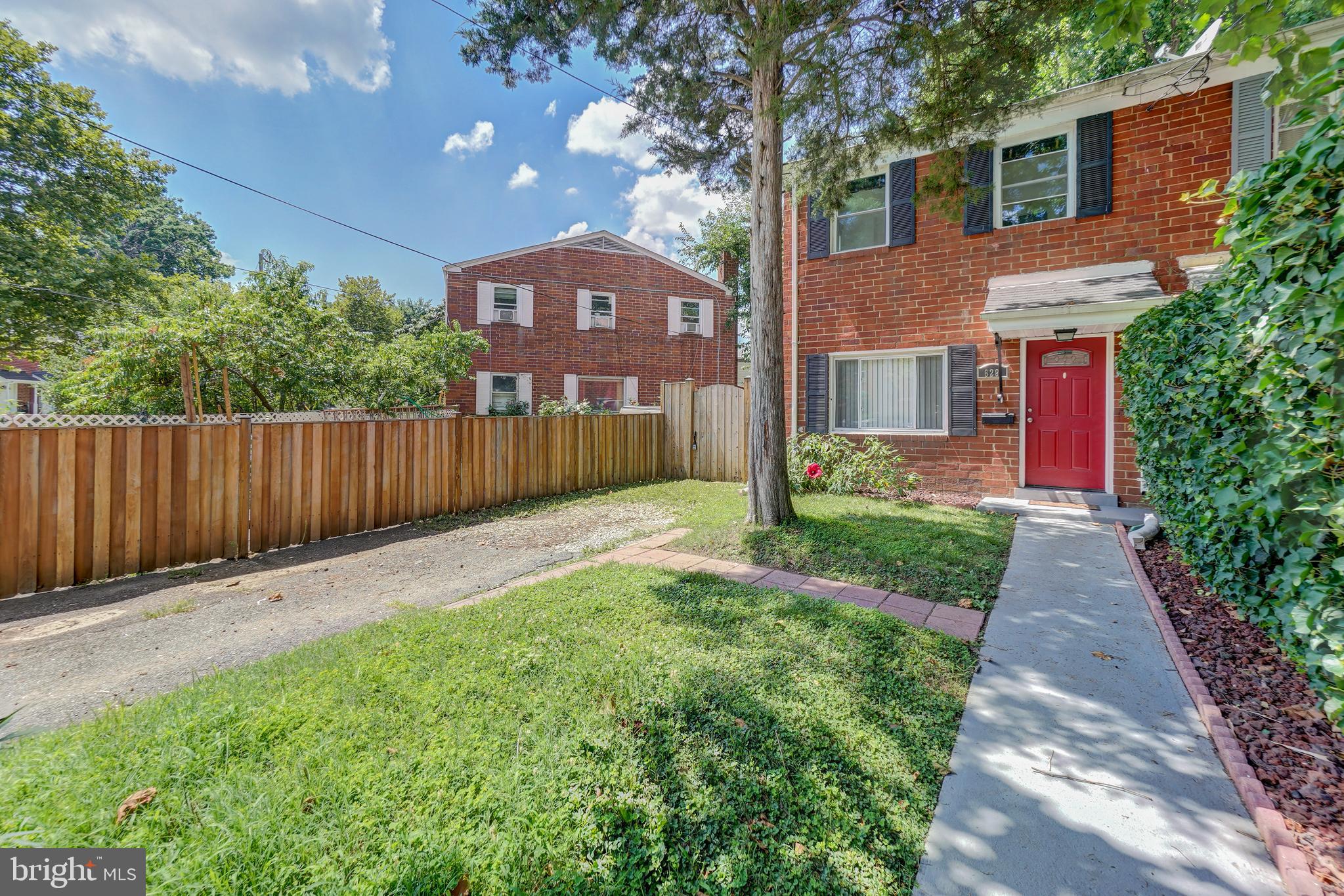 628 Four Mile Road Alexandria, VA 22305 - Photo 1 of 29 a front view of a house with a garden and trees