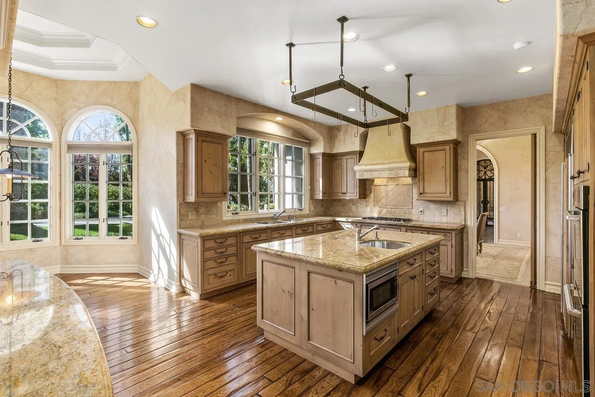 17178 Circa Oriente Rancho Santa Fe, CA 92067 - Photo 18 of 27 a kitchen with stainless steel appliances granite countertop a stove and a view of living room