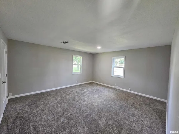 an empty room with a window and a mirror