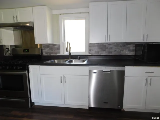a kitchen with granite countertop white cabinets and black appliances