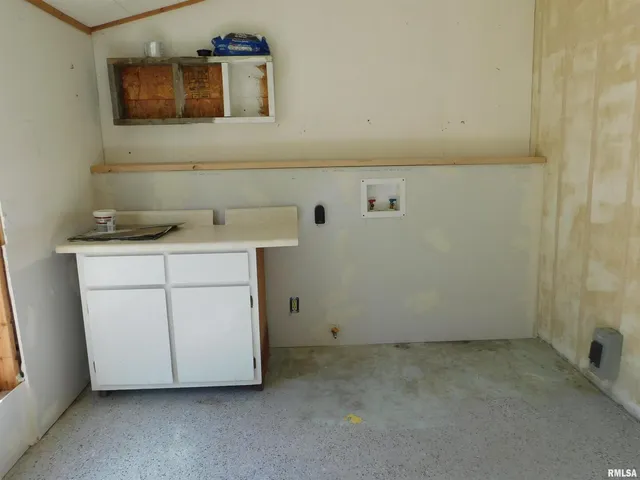 a utility room with a sink a vanity and a mirror