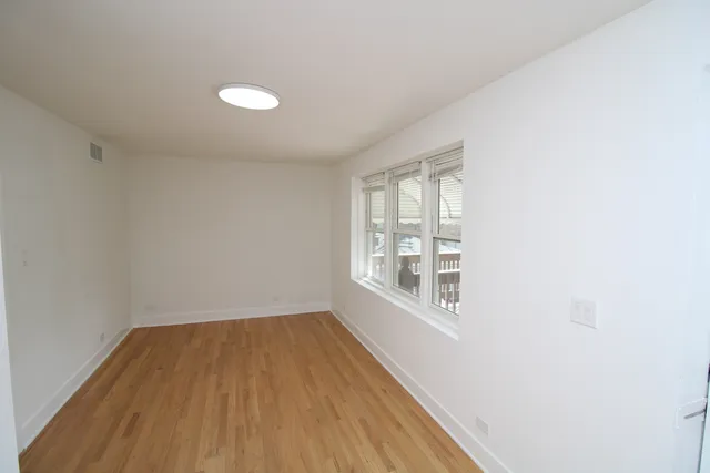 a view of a room with wooden floor and windows