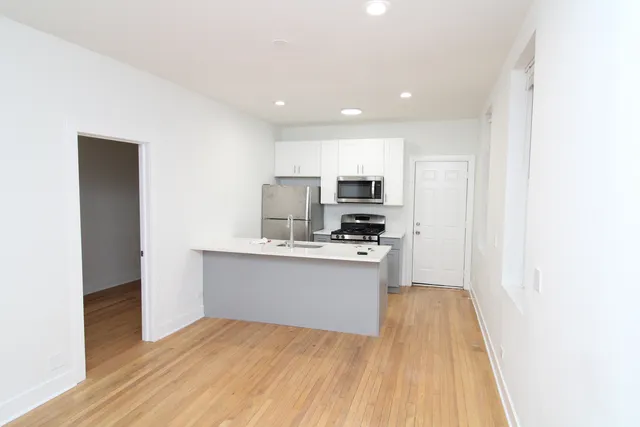 a kitchen with stainless steel appliances a refrigerator and a stove top oven