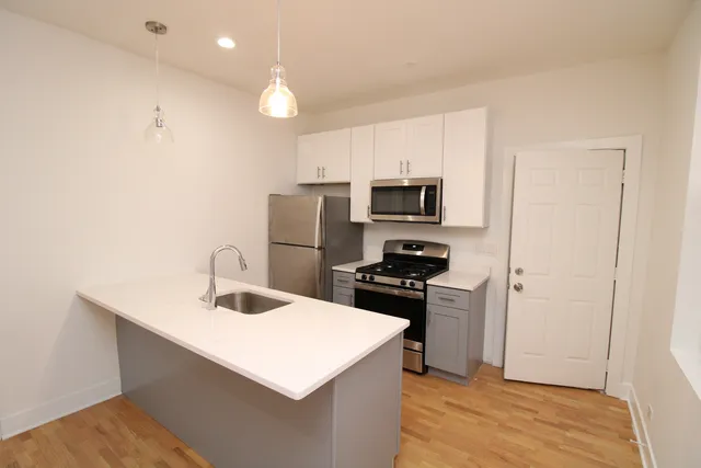 a kitchen with a sink a stove a refrigerator a microwave and cabinets