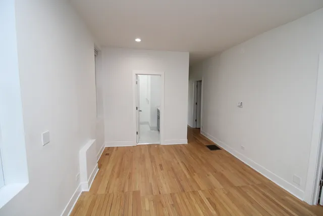 a view of a room with wooden floor and a window