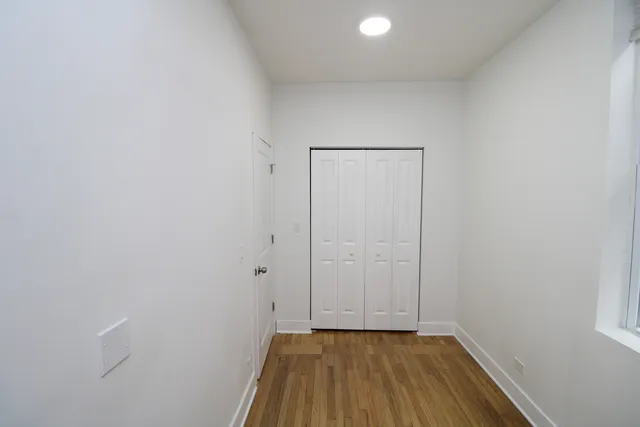 a view of a room with wooden floor and white doors