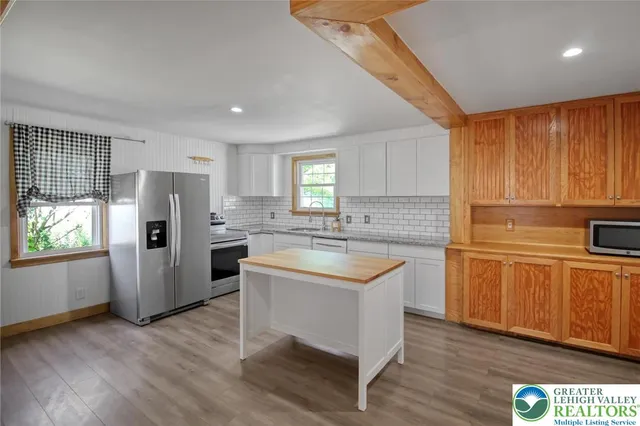 a kitchen with stainless steel appliances a refrigerator and a stove top oven