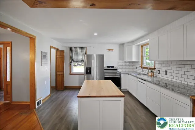 a bathroom with a granite countertop sink a toilet and mirror