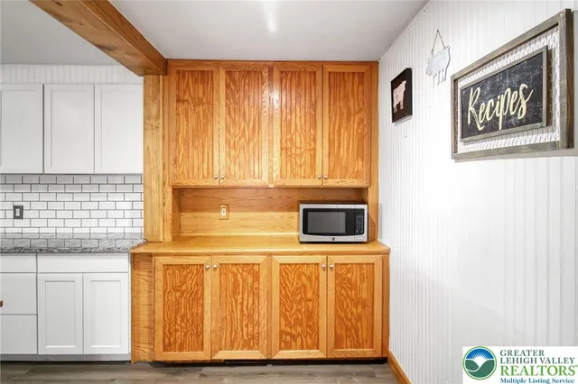 a view of an empty room with wooden floor and closet
