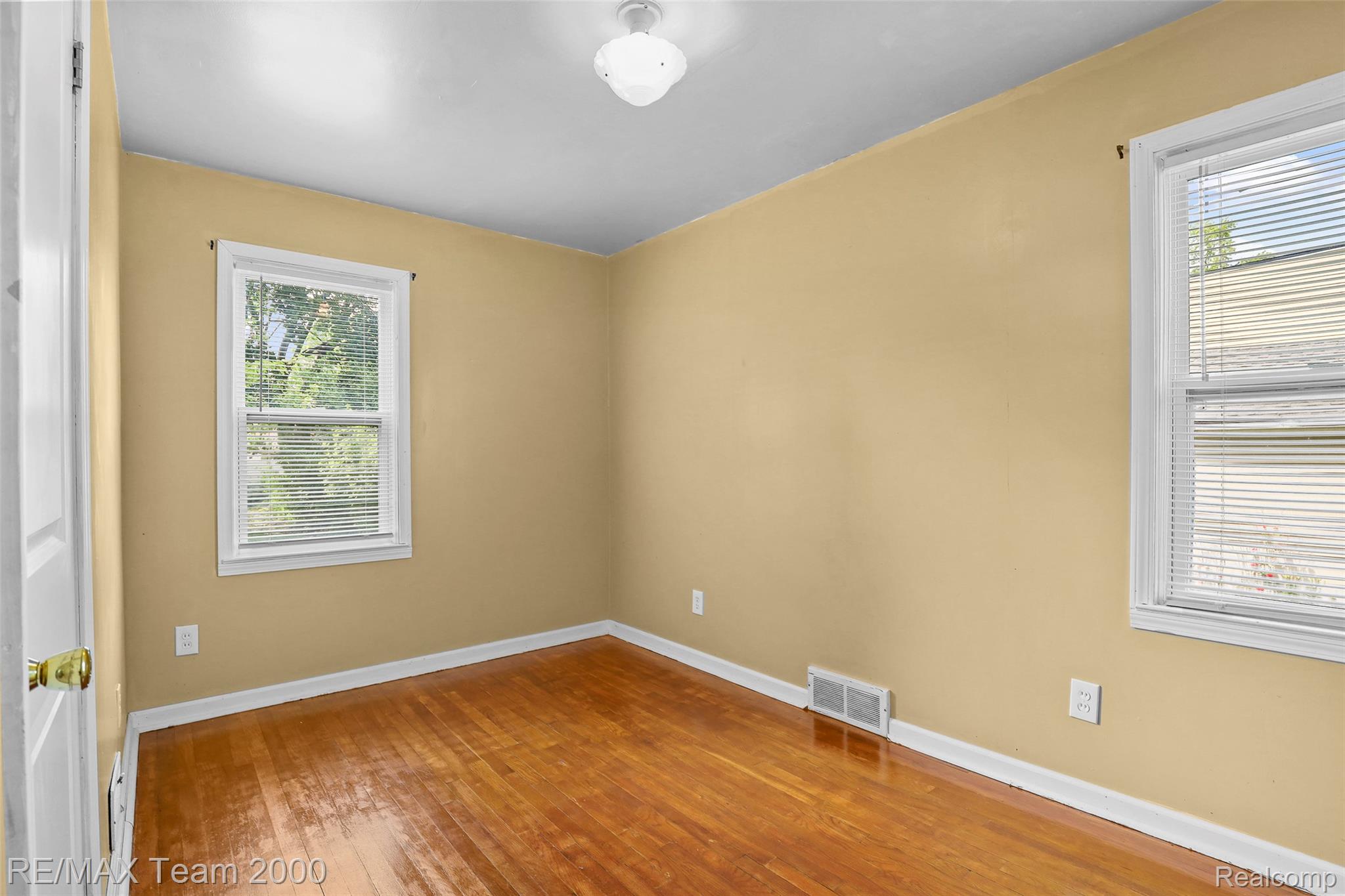 3130 Chestnut Street Dearborn, MI 48124 - Photo 17 of 30 Room featuring wood-finish flooring, two windows with blinds, a flush-mount ceiling light, and light-toned walls