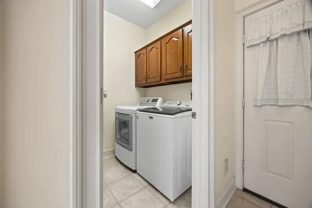 a utility room with cabinets washer and dryer