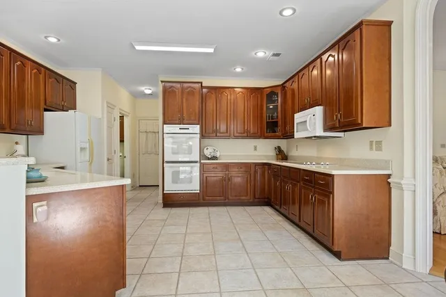 a kitchen with stainless steel appliances granite countertop a refrigerator and a stove top oven