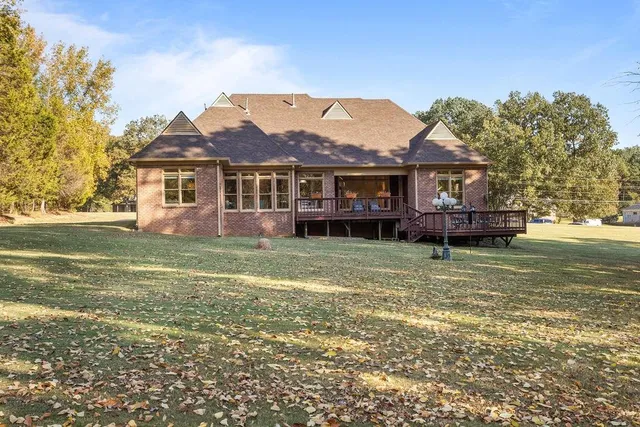a front view of a house with a garden and lake view