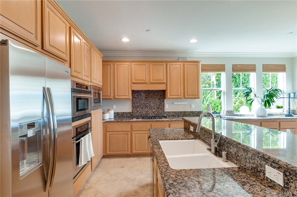 2470 Bulrush Circle Corona, CA 92882 - Photo 14 of 64 a kitchen with kitchen island granite countertop a stove a sink and a refrigerator