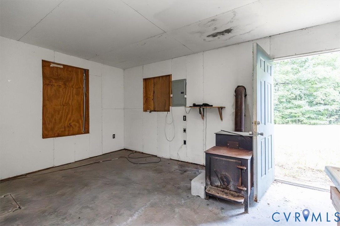 6610 Blenheim Road Powhatan, VA 23139 - Photo 16 of 26 Garage featuring a wood stove and electric panel