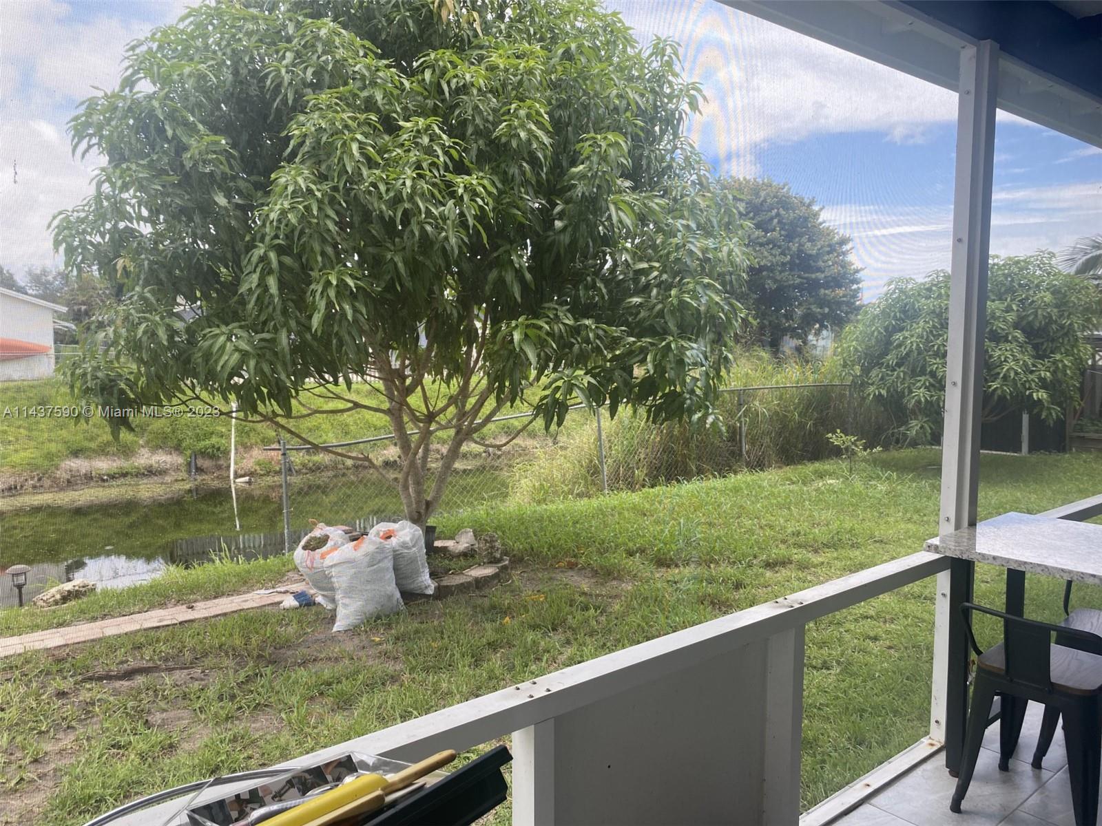 22620 Southwest 65th Way Boca Raton, FL 33428 - Photo 23 of 23 a backyard of a house with two chairs and a table