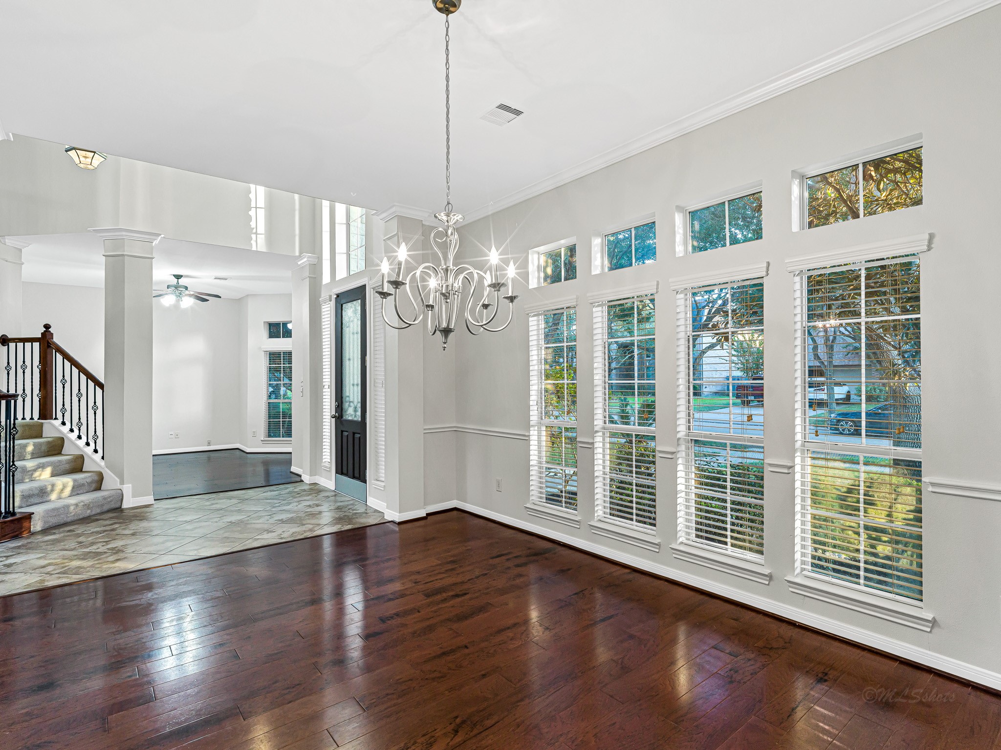 2714 Misty River Lane Richmond, TX 77406 - Photo 11 of 50 a view of an empty room with wooden floor and a chandelier
