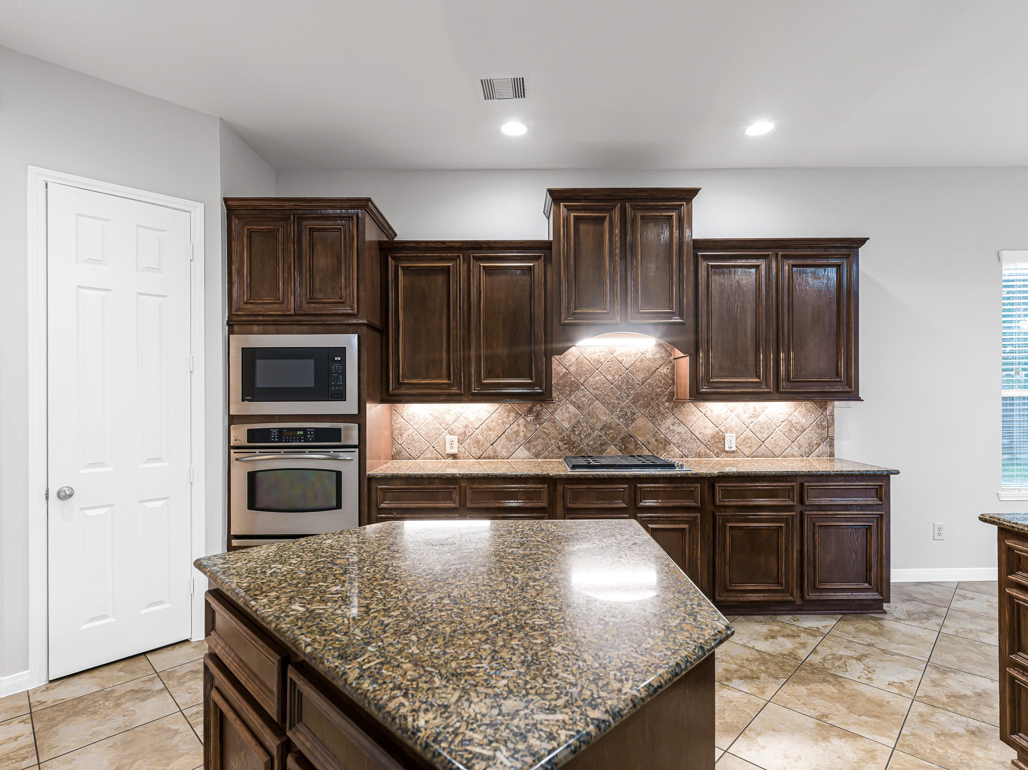 2714 Misty River Lane Richmond, TX 77406 - Photo 14 of 50 a kitchen with kitchen island granite countertop wooden cabinets and a sink