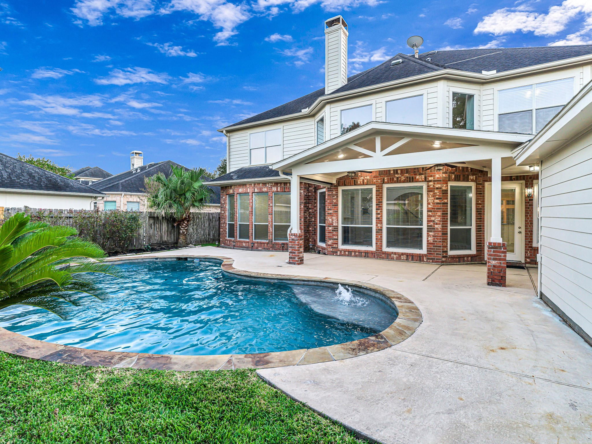 2714 Misty River Lane Richmond, TX 77406 - Photo 43 of 50 a view of a white house with a swimming pool and porch with furniture