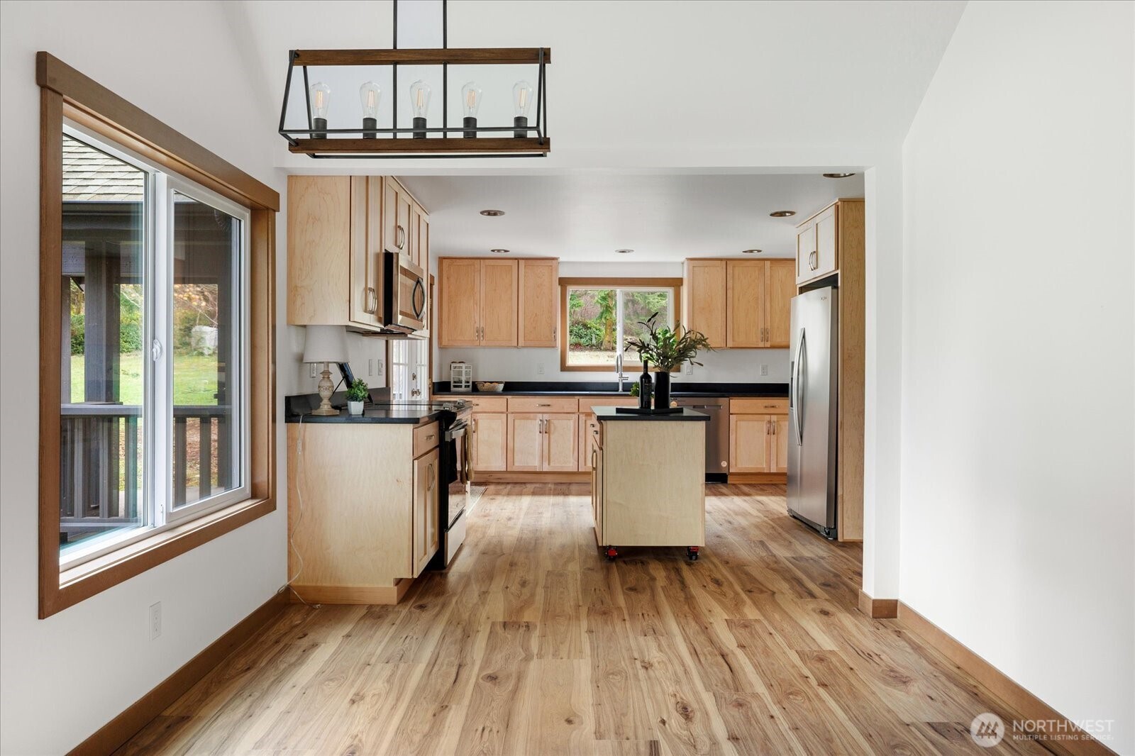 2341 Libbey Road Coupeville, WA 98239 - Photo 9 of 36 a living room with stainless steel appliances a dining table wooden floor and a large window