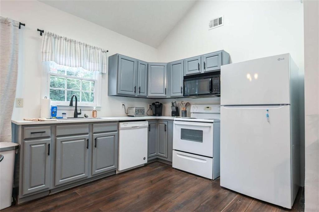 398 Arch Street Athens, GA 30601 - Photo 12 of 27 a kitchen with a white cabinets and white appliances