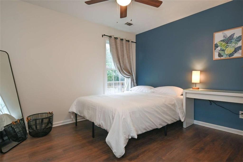 398 Arch Street Athens, GA 30601 - Photo 18 of 27 a bed sitting in a bedroom next to a window and a chandelier