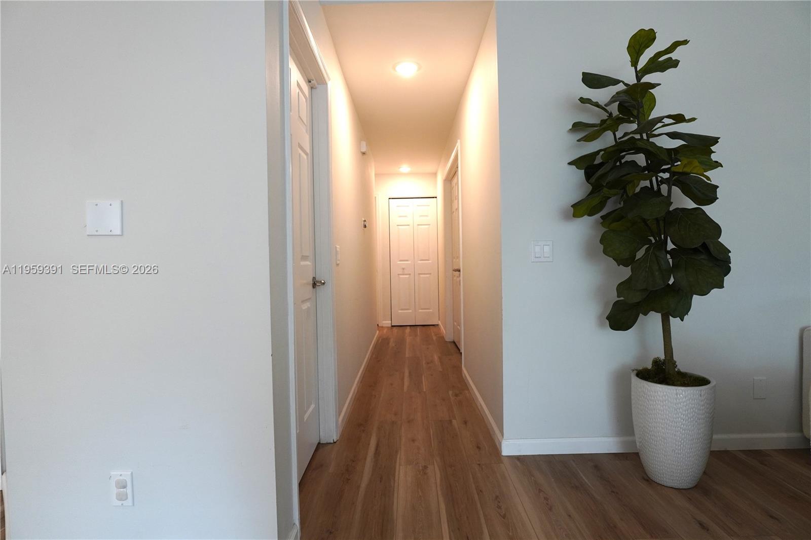 5741 Coach House Circle, Unit H Boca Raton, FL 33486 - Photo 12 of 34 a view of a hallway with wooden floor and a potted plant